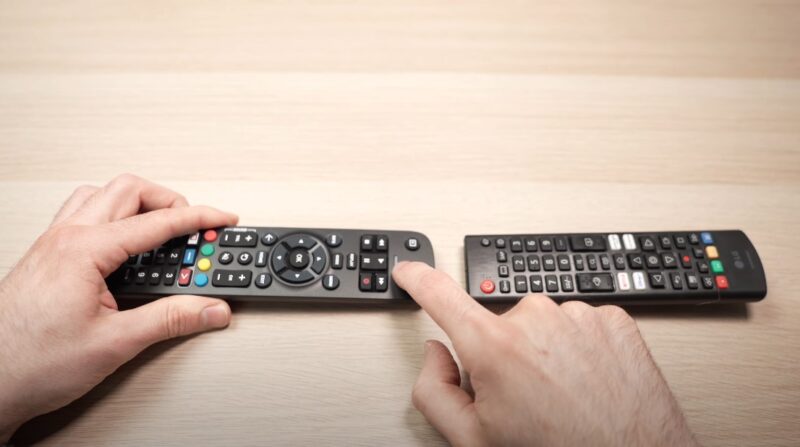 Two remotes on a wooden table