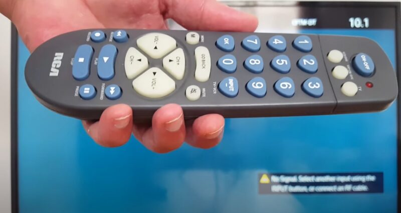 Close up photo of a hand holding TV remote